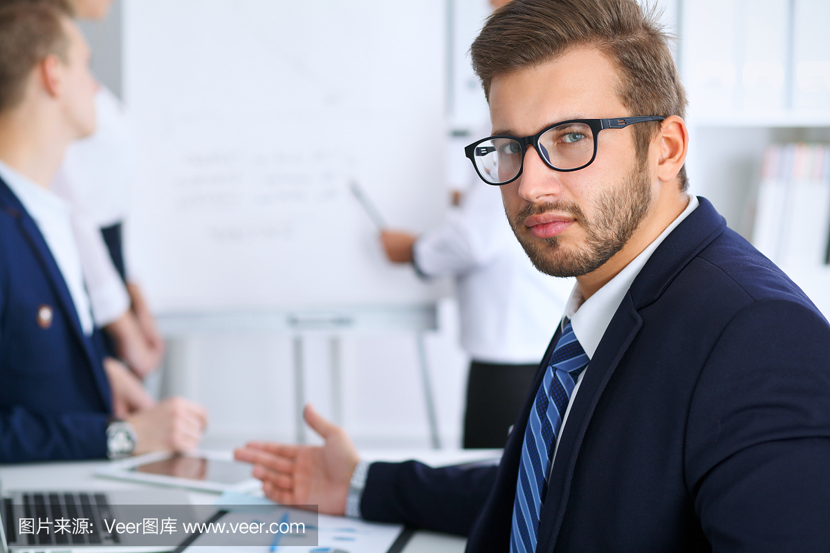 商务人士在办公室会议。专注于戴眼镜的开朗的