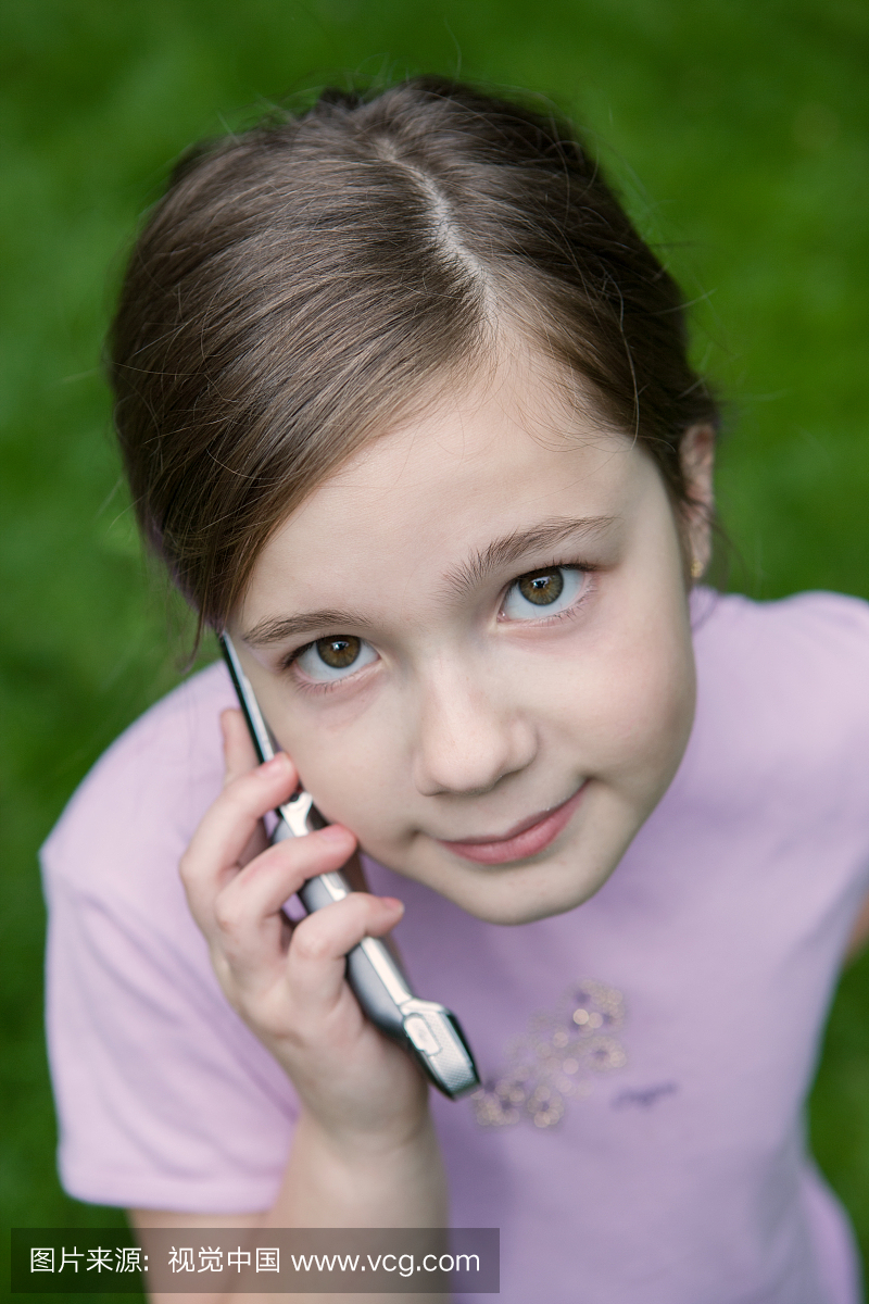 快乐9岁的女孩谈手机,高角度视图