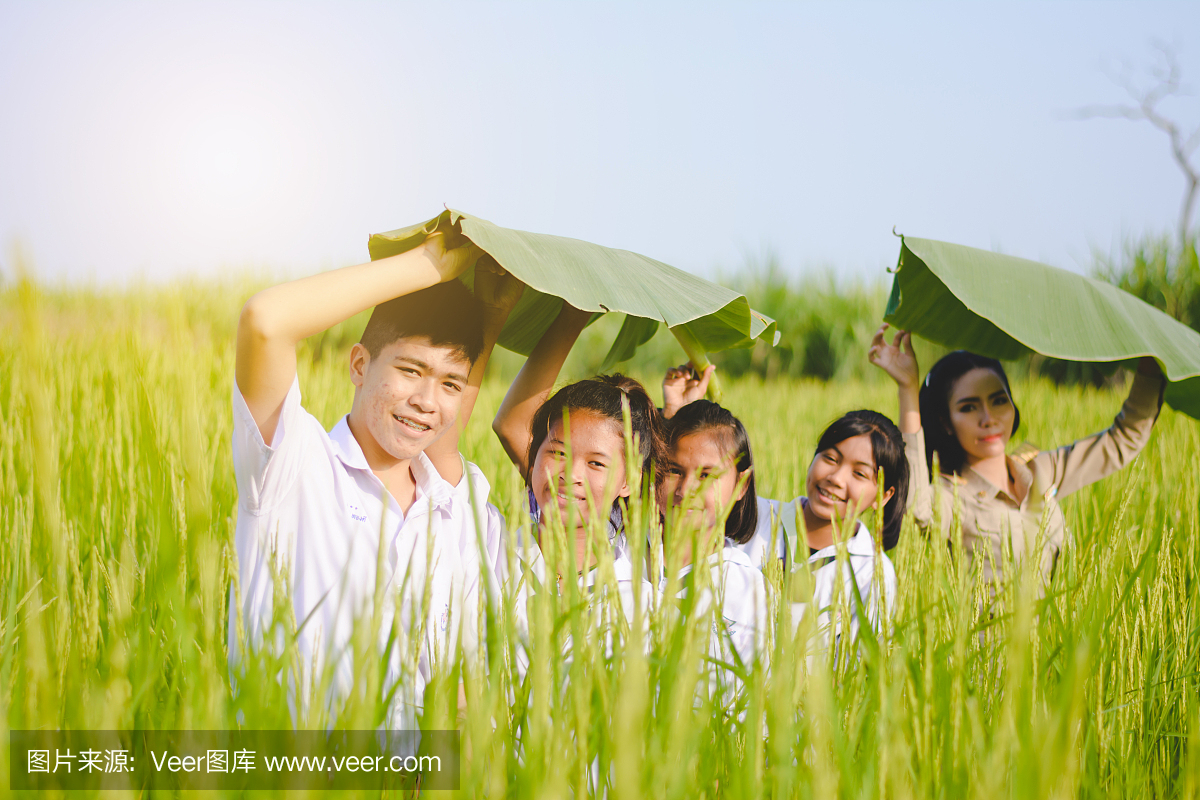 美丽的泰国老师在统一的教学学生在室外学习自