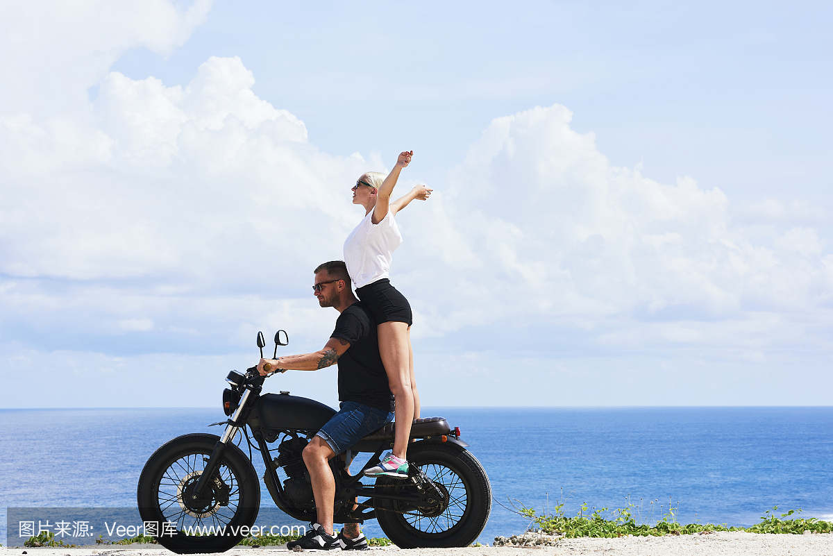 幸福的年轻女人感觉兴奋,而与男友在海洋海岸