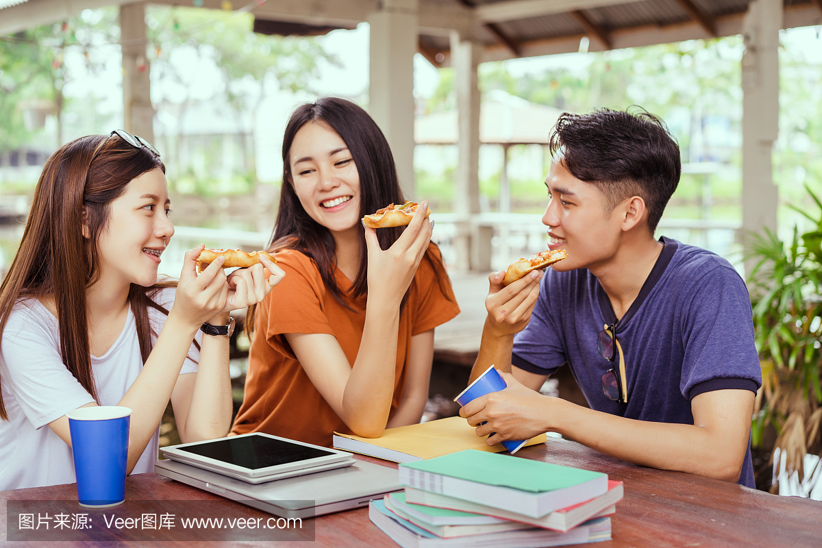 学生亚洲组一起吃披萨在打破时间早上下一个学