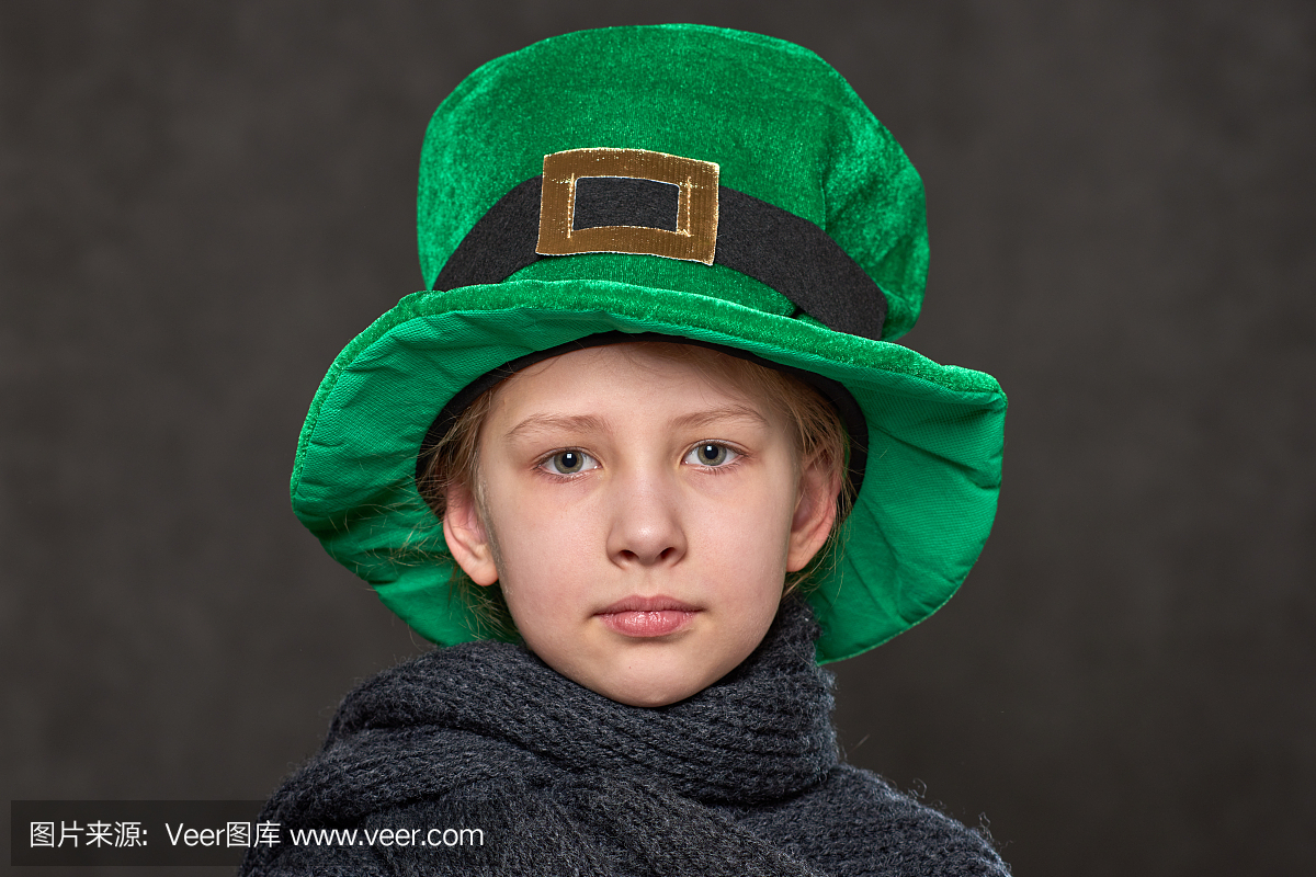 年轻女孩在绿色妖精的帽子和灰色针织围巾