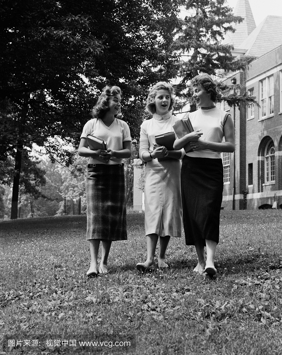 美国,纽约纽约市,三名女大学生走在大学大楼前