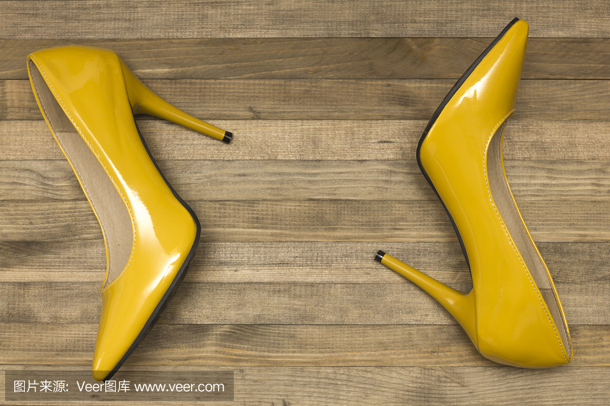 黄色妇女鞋跟高跟鞋在木背景顶视图
