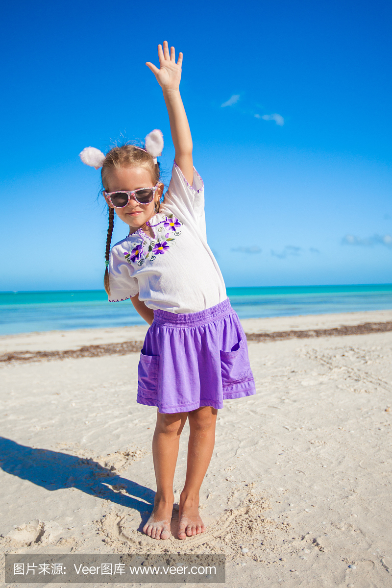 可爱的小女孩在异国情调的海滩上的复活节服装