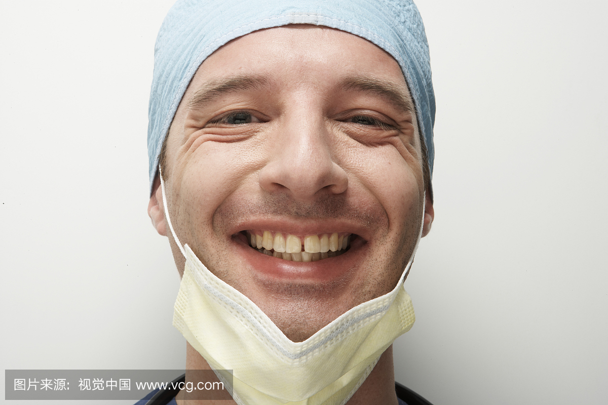 男医生戴着手术口罩和帽子,微笑,肖像