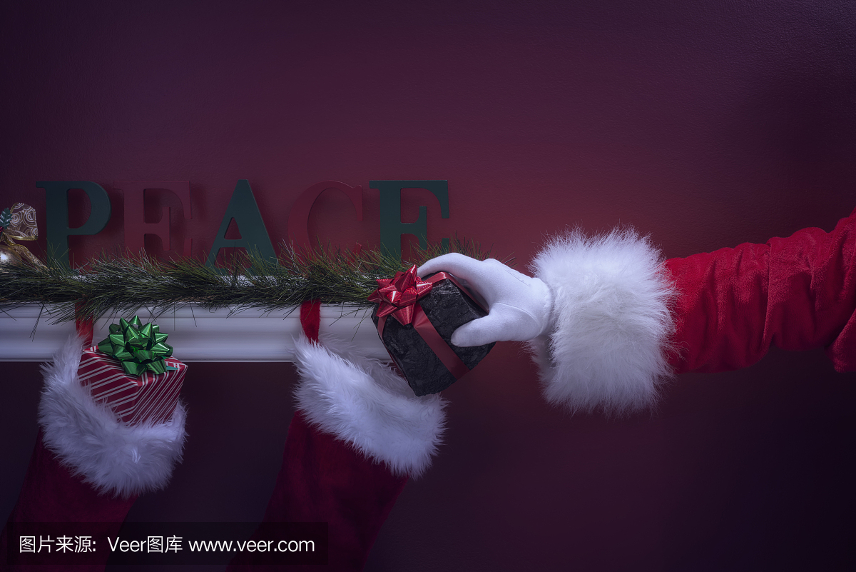 圣诞老人的手将煤放入圣诞袜