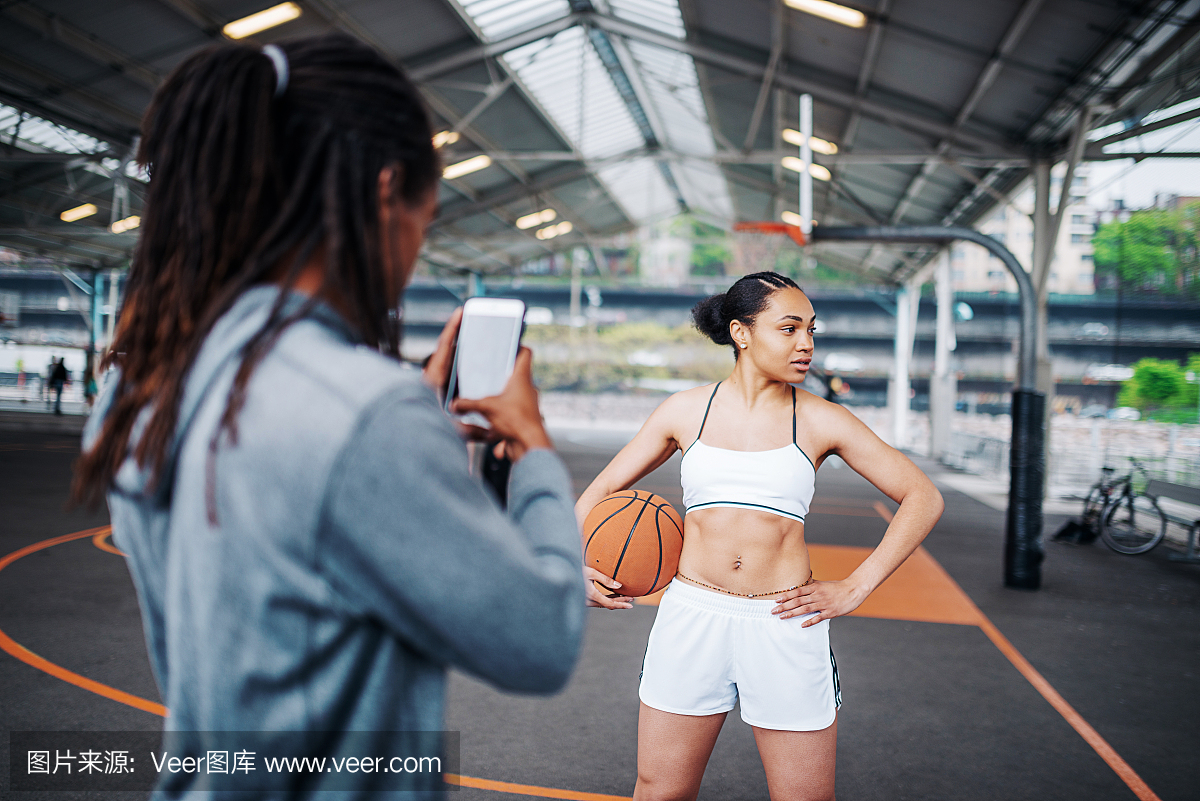 男朋友拍他的女孩在篮球场上的照片