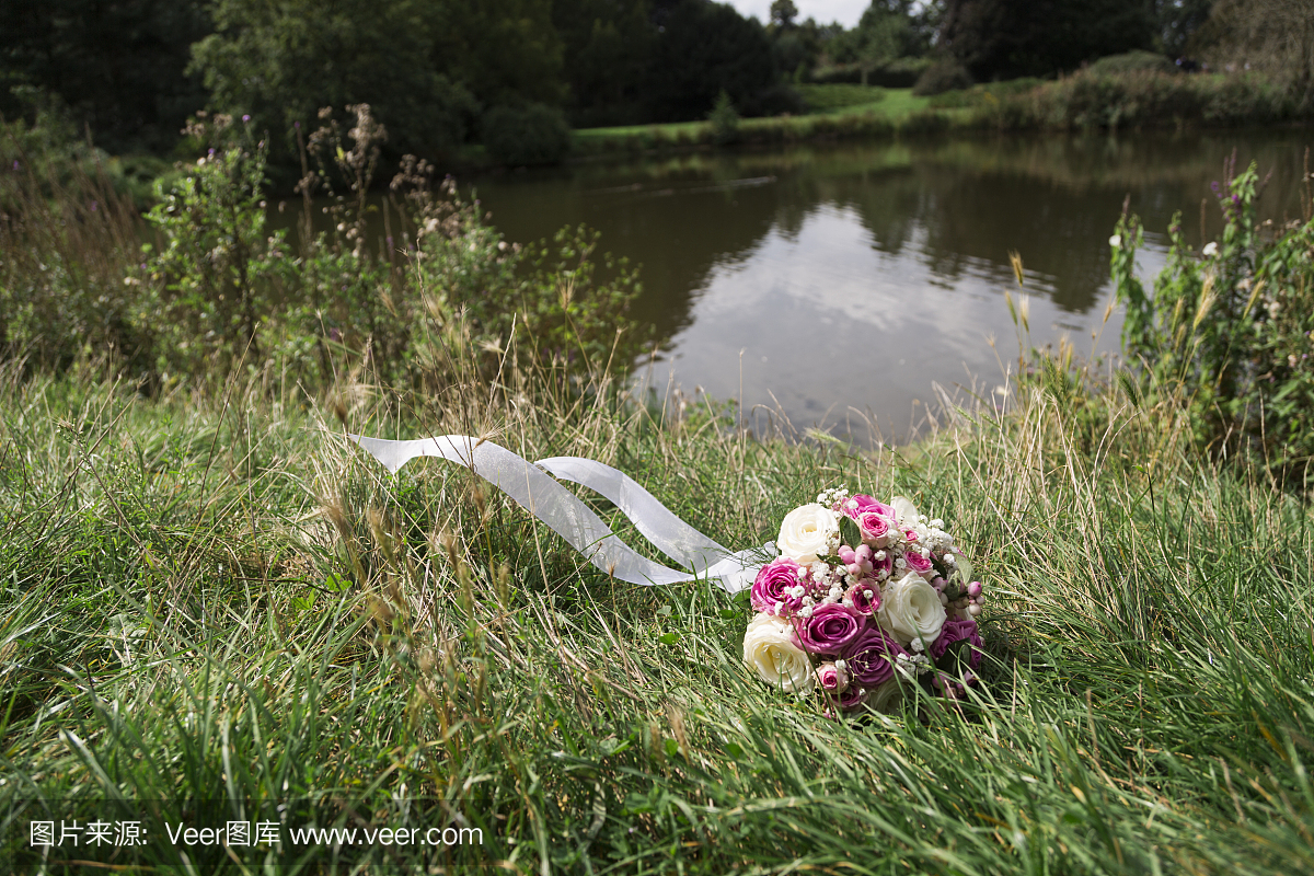 浪漫新鲜的婚礼花束在绿色草地上