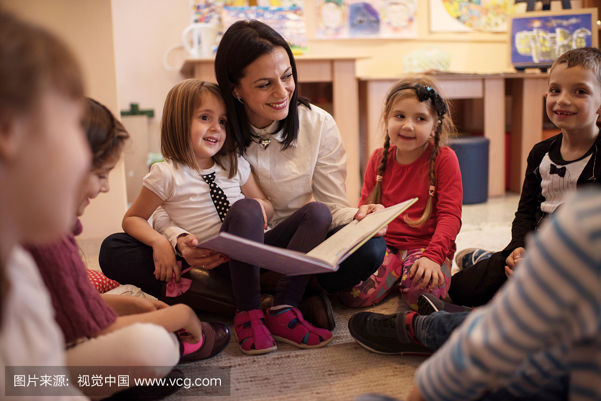 快乐的幼儿老师讲故事给小孩们。