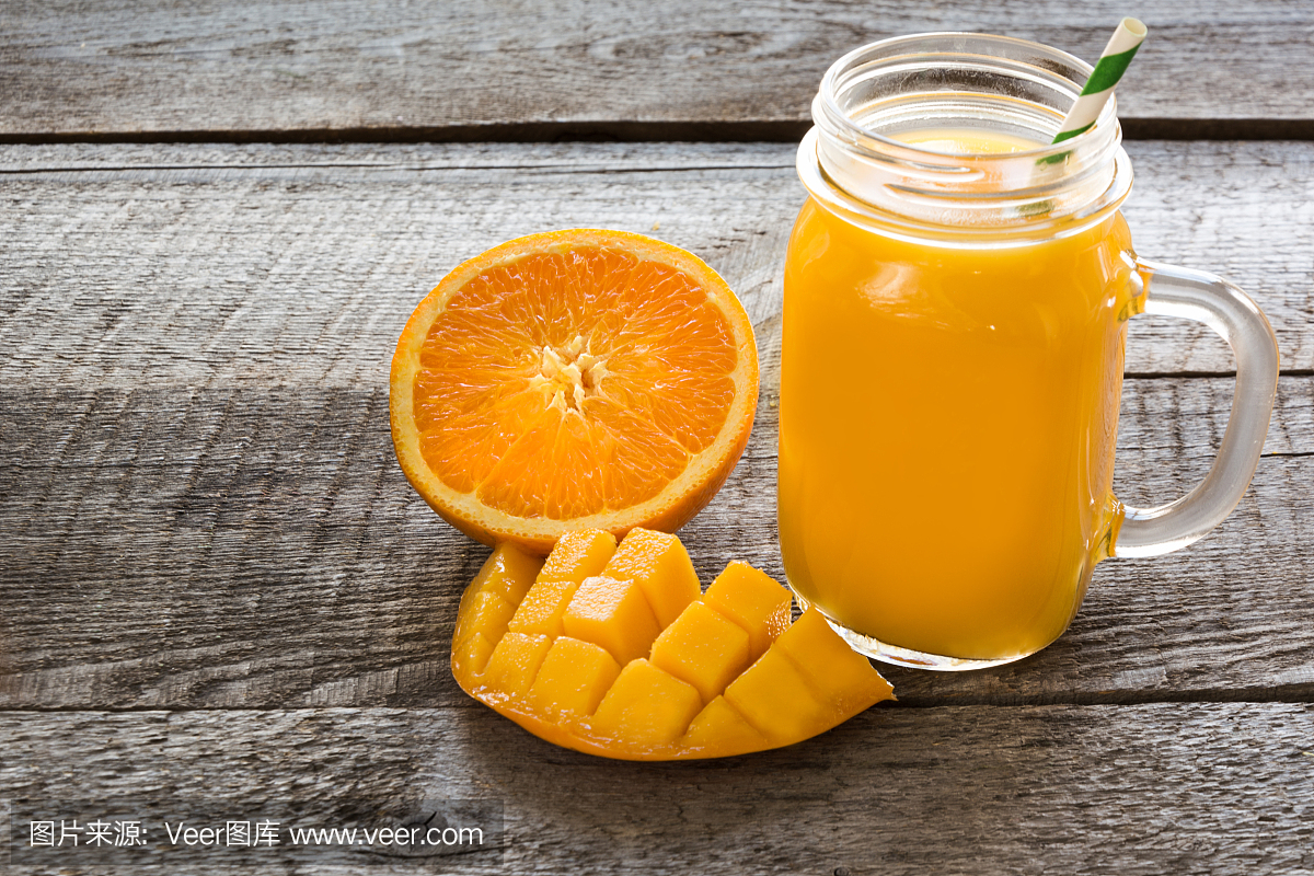 热带果汁与果子:芒果,橙色在一个玻璃梅森罐在