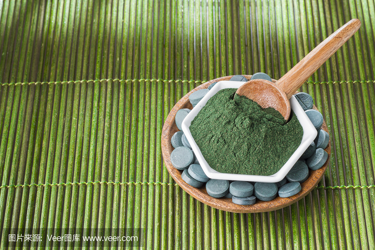 海藻粉螺旋藻在木制的背景上