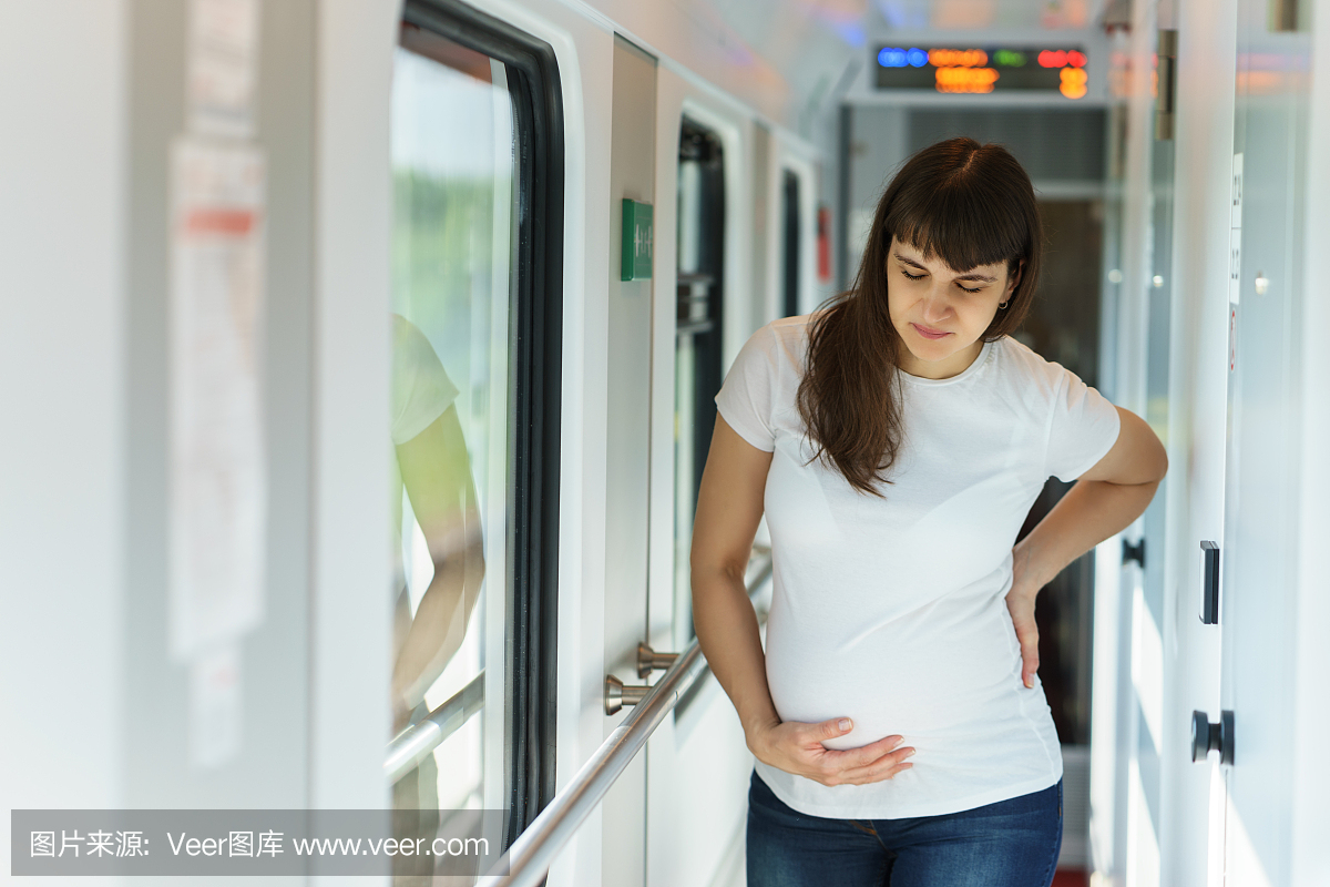 一名欧洲孕妇穿着T恤衫,在铁路旅行时正在恢复