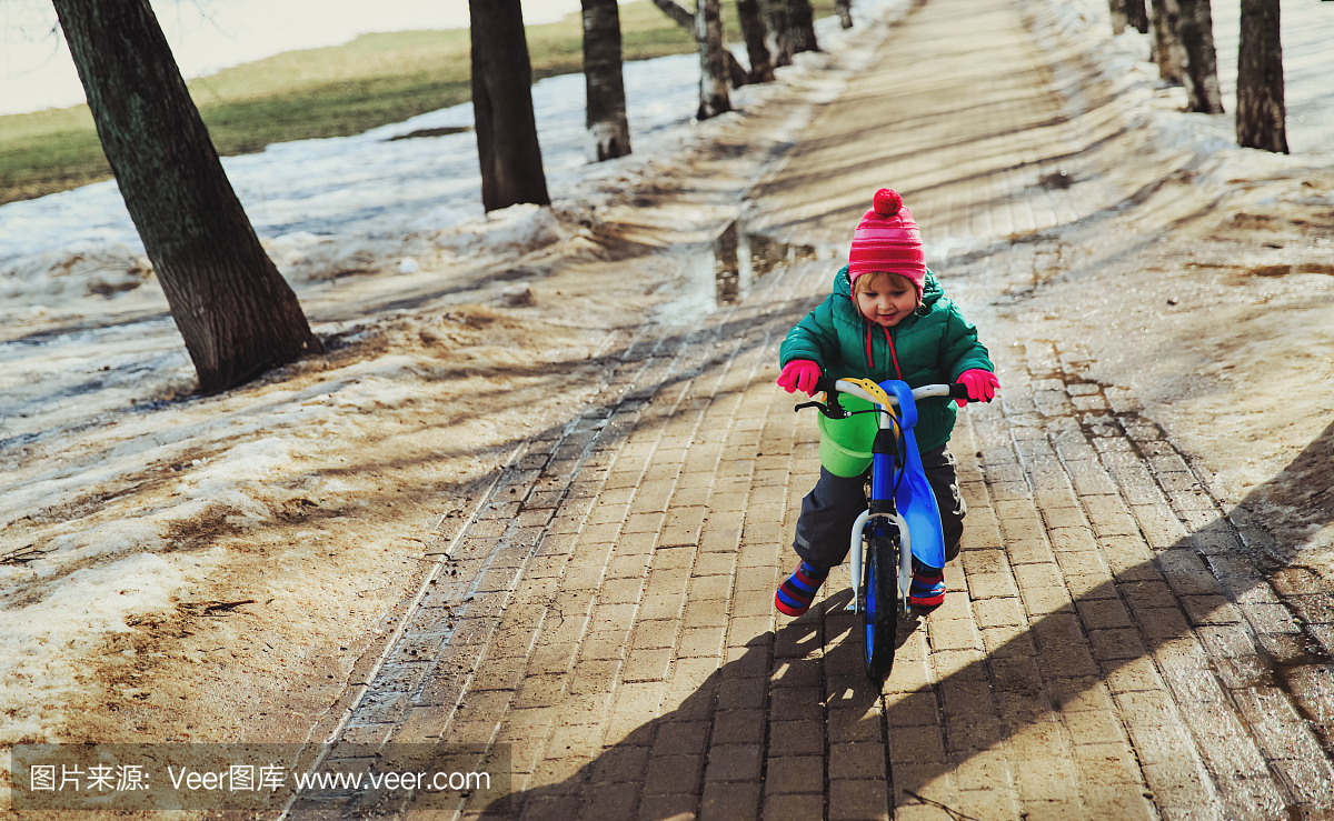 小女孩在冬天或春天骑自行车