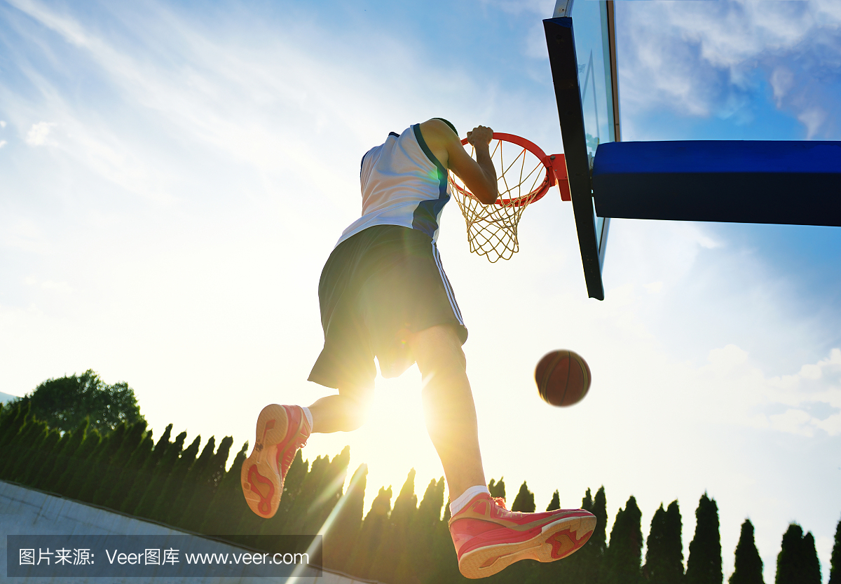 街头篮球运动员执行贫民窟扣篮。