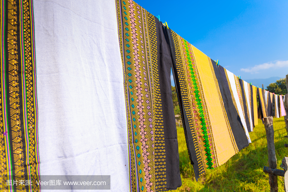 五颜六色的泰国布裙在风中飘扬,在稻田里草地
