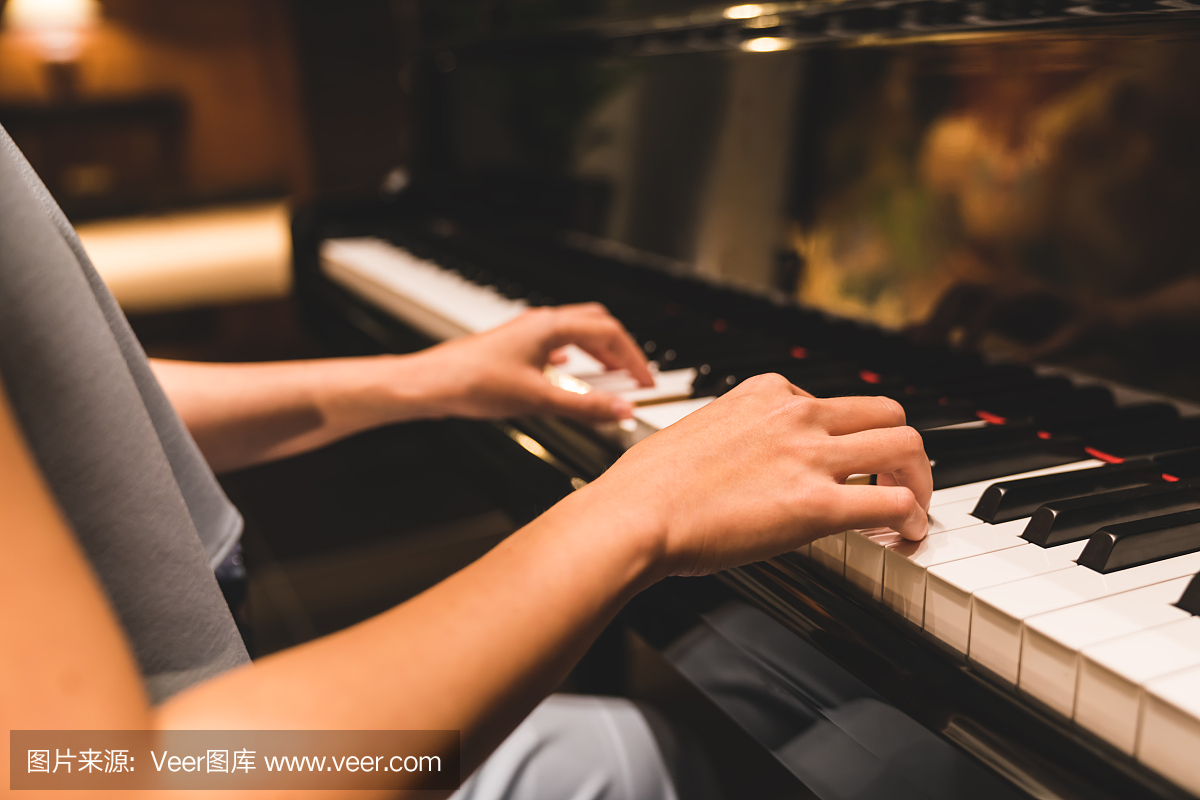 亚洲女人手弹钢琴的键盘在浪漫的气氛中。乐器,独奏钢琴家,歌曲作曲家,爱好,练习研究或婚礼事件概念