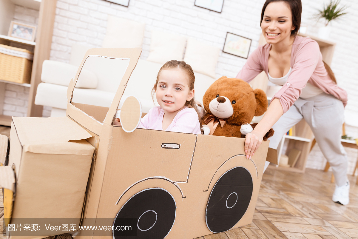 一位小女孩和她的母亲正在玩玩具车。