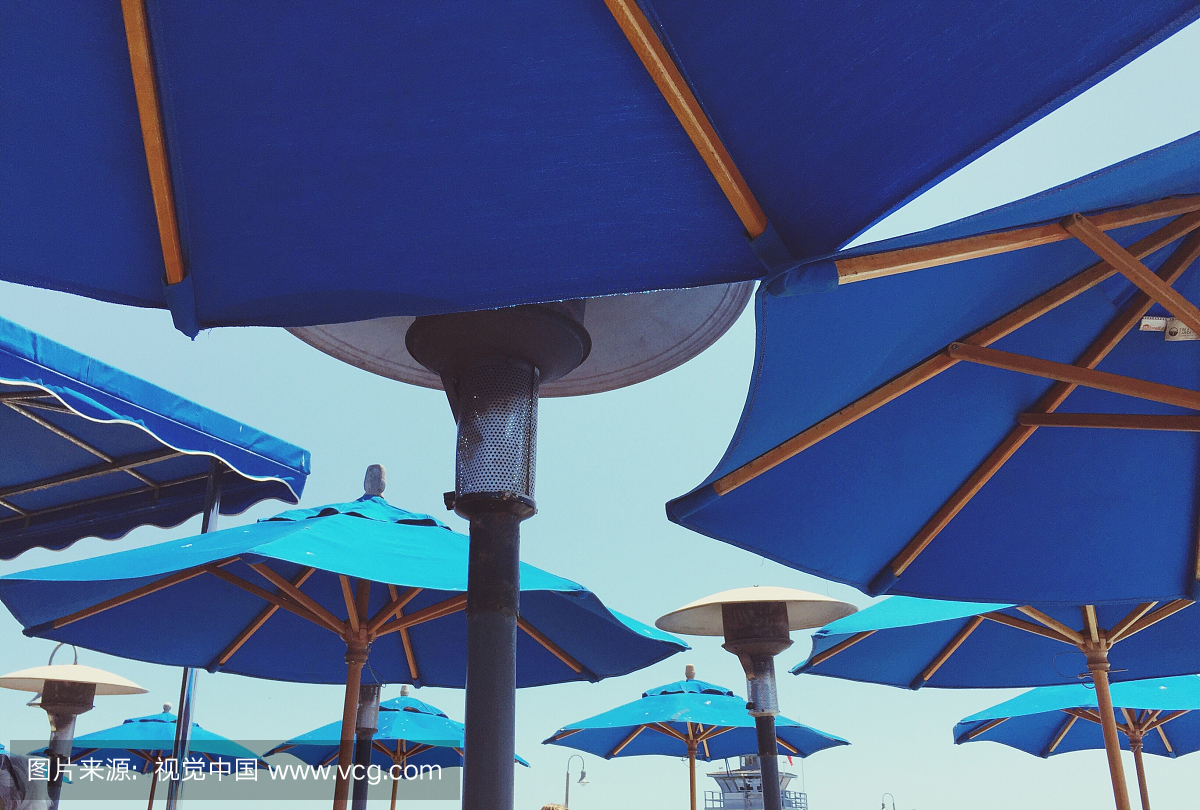 蓝色遮阳伞对透明天空的低角度视图