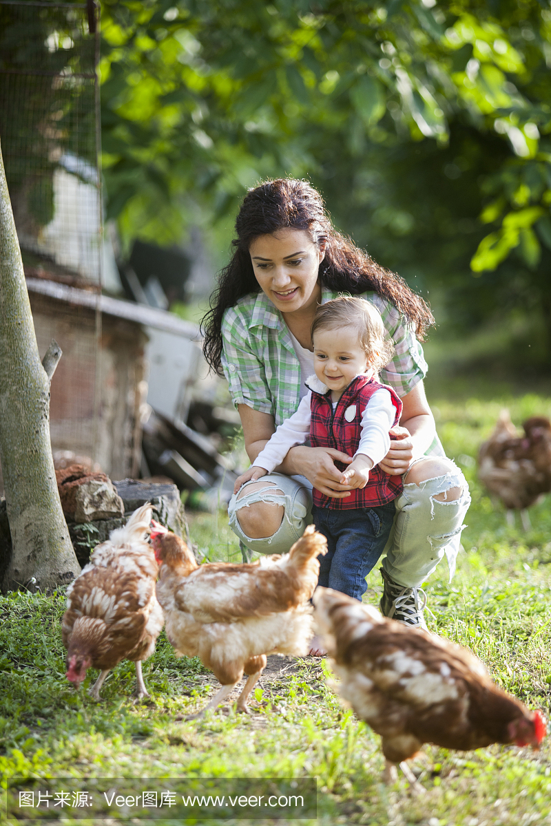 母亲和女儿在养鸡场玩得开心
