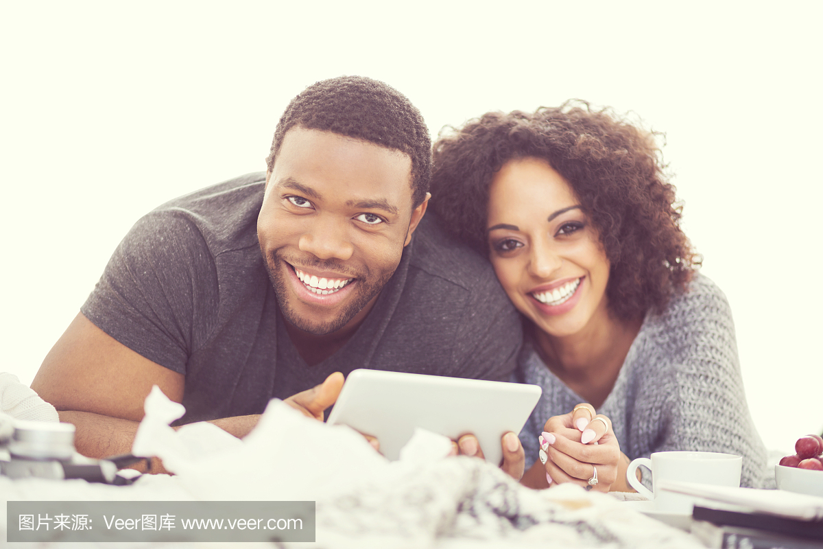 非裔美国人使用数字平板电脑的幸福的情侣