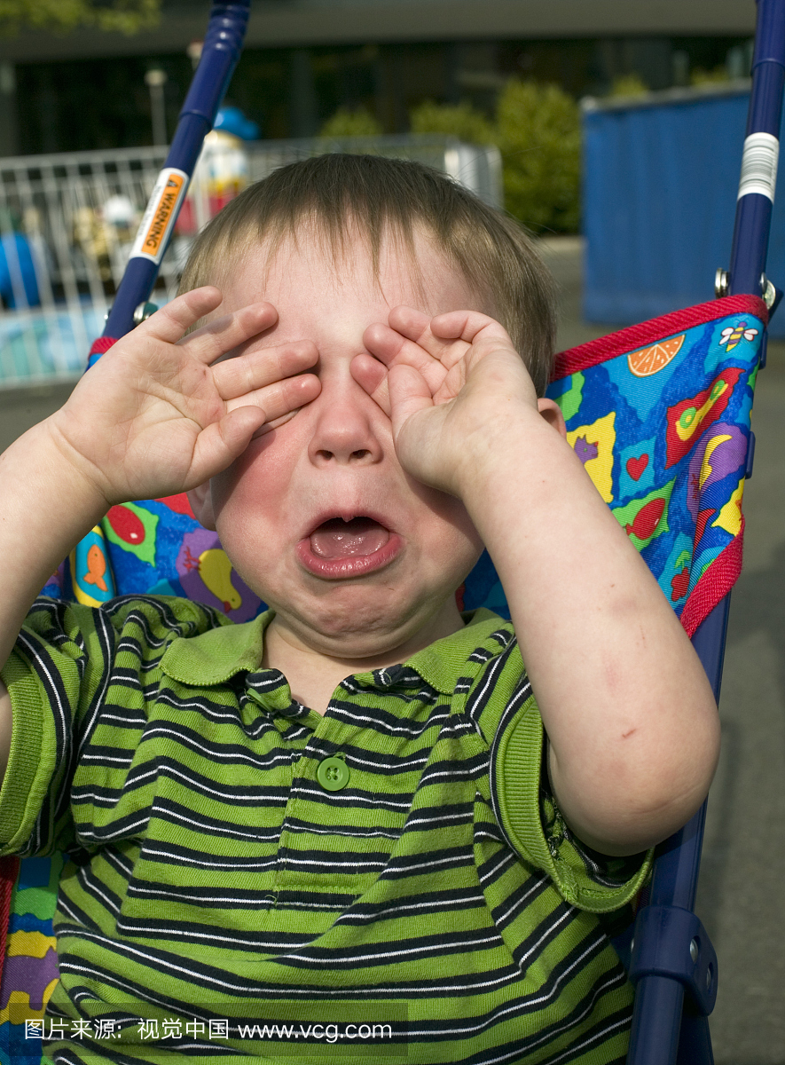 男孩(2-4)坐在婴儿车上,揉眼睛,哭泣