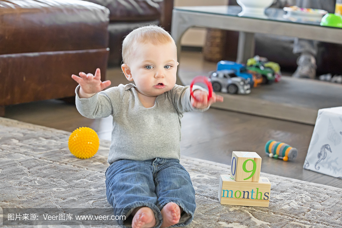 九个月大的男孩在地板上玩玩具