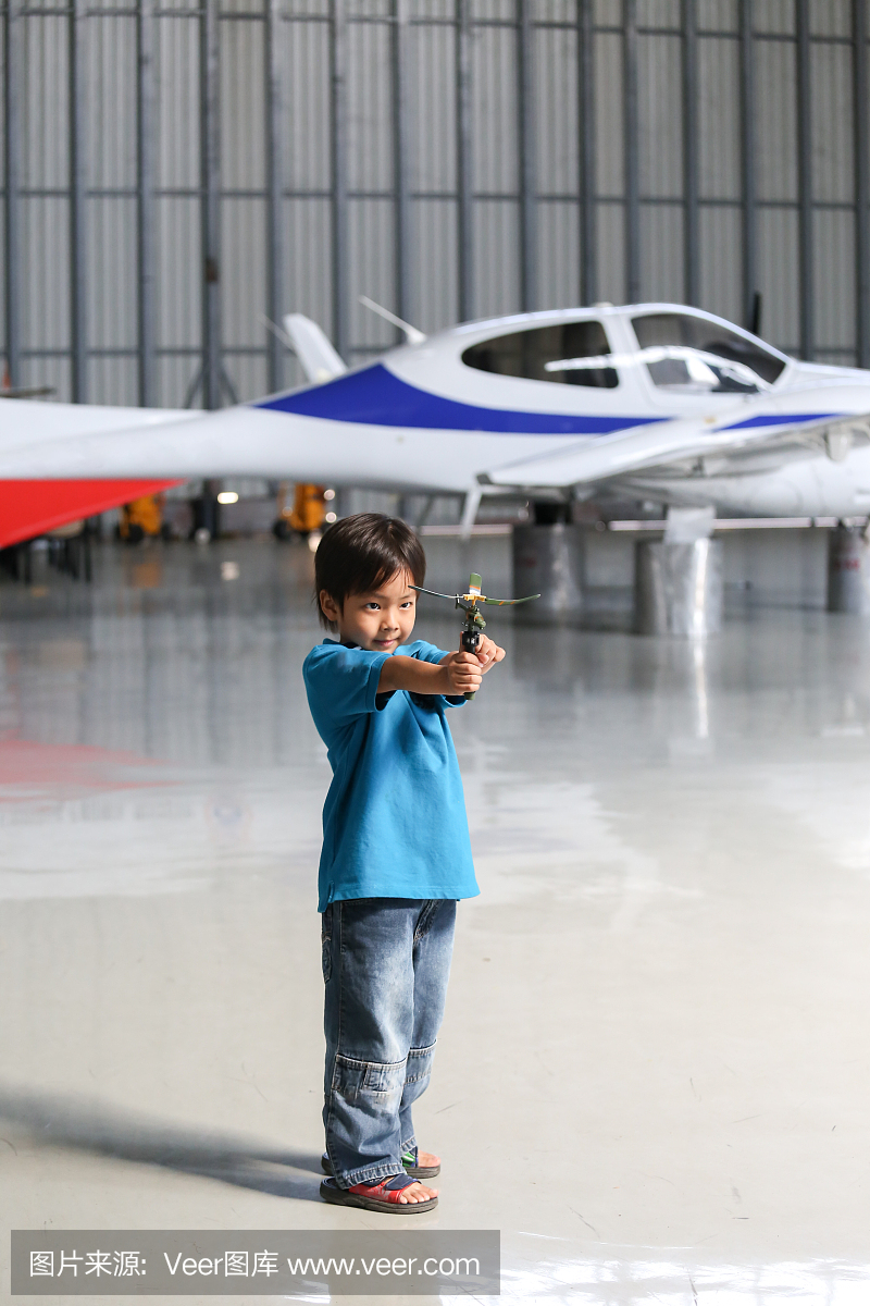 七岁的亚洲男孩在机库玩玩具