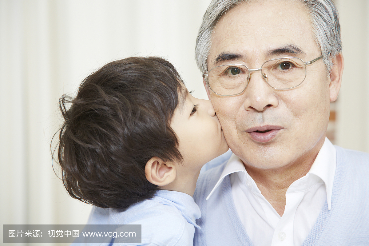 Boy kissing his grandfather