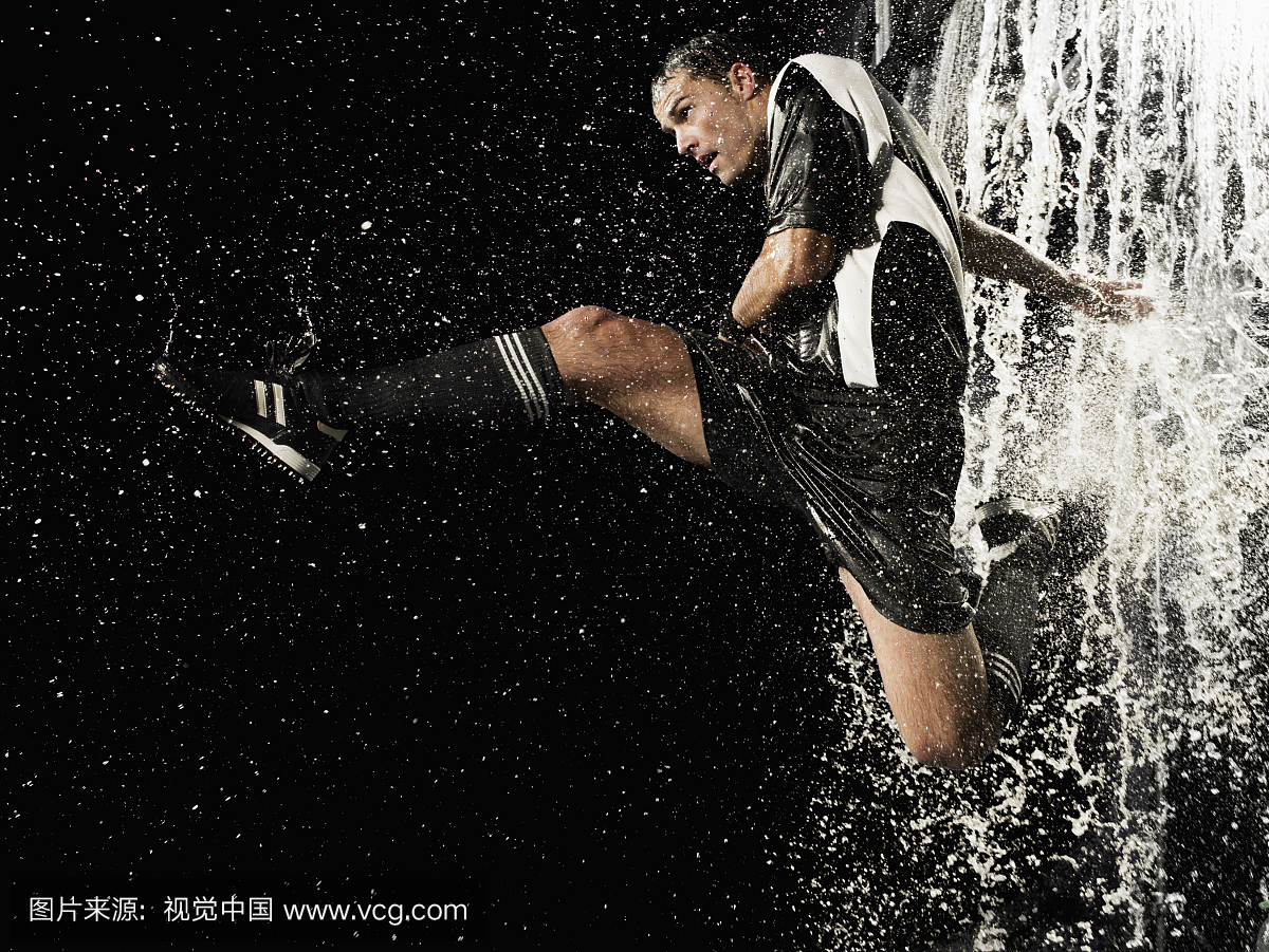男足球员跳过水墙,侧视图