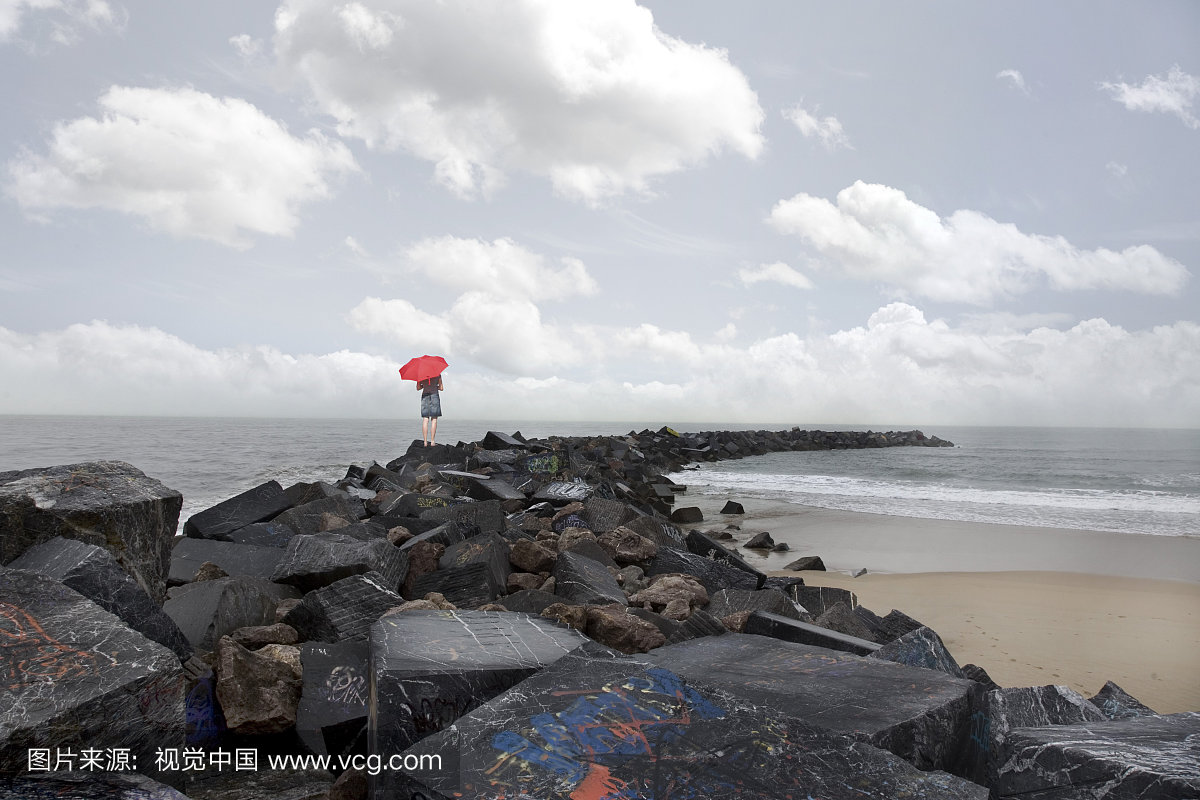 红色的伞在岩石,圣塞巴斯蒂安,巴斯克地区,西班