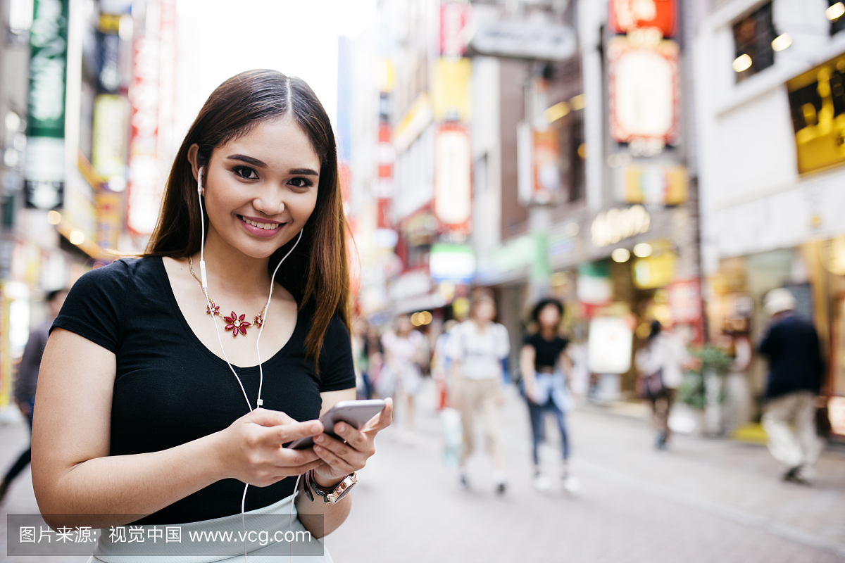 年轻的西班牙裔女人,微笑着看着相机,购物,东京