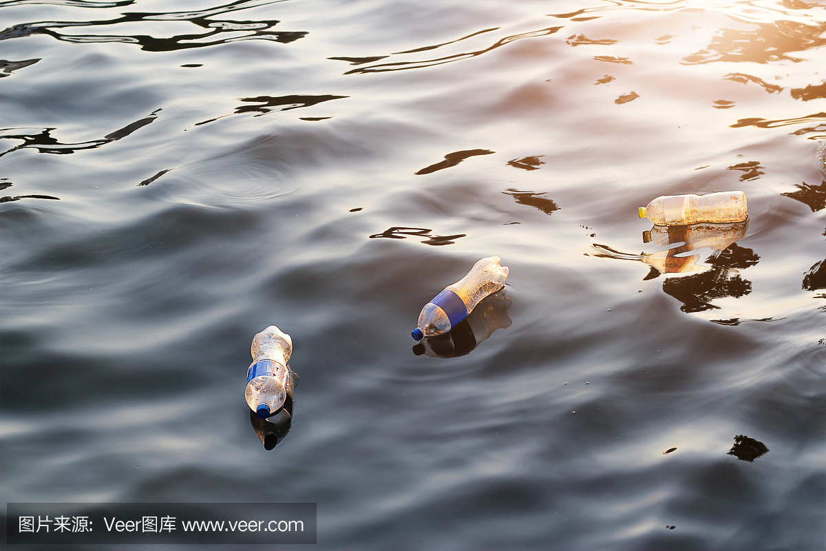 日落中的塑料垃圾在河里,污染和环境的概念