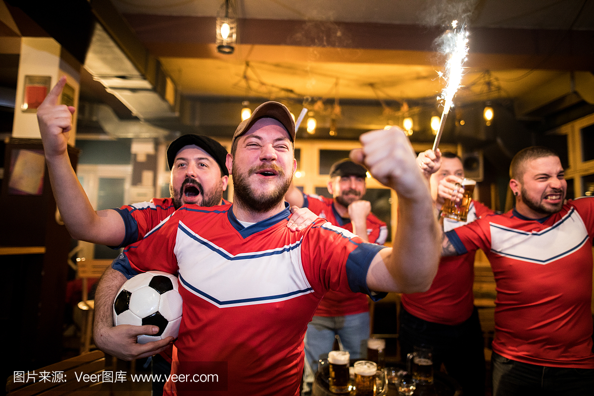 激动的人在酒吧里看足球比赛