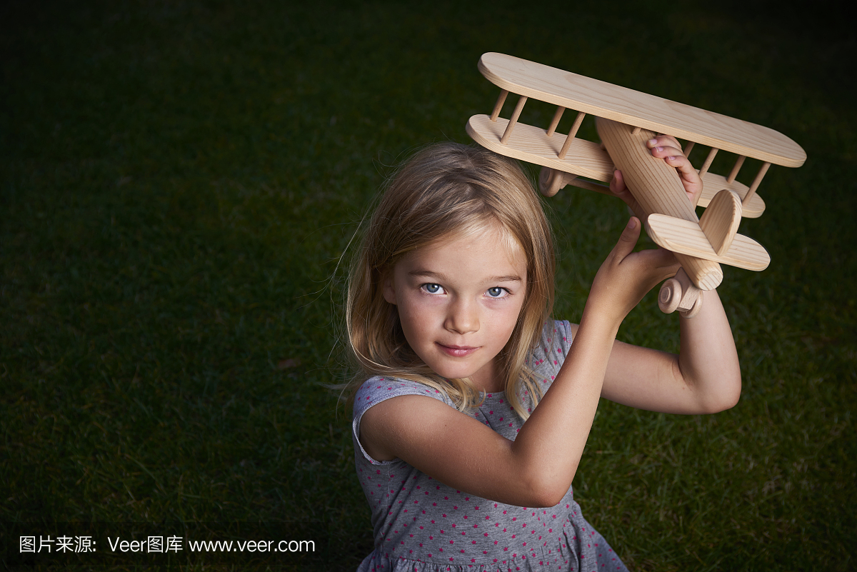 玩玩具木飞机的儿童金发女孩