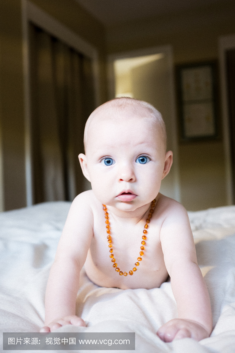 有蓝色眼睛和琥珀项链的婴儿女婴