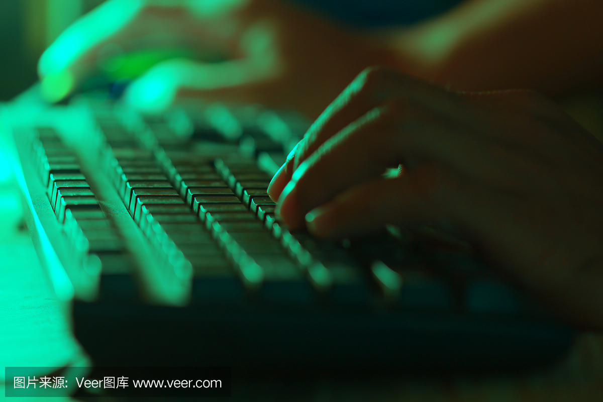 人的手使用键盘工作。图像的颜色绿色。
