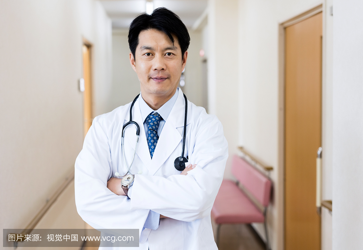 自信的日本医生站在走廊的肖像