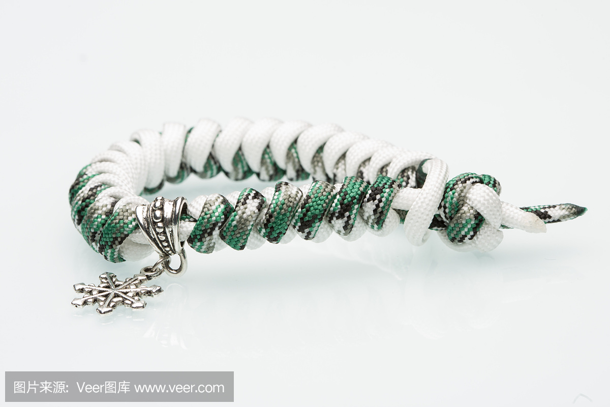 在白色背景上的绿色编织手镯。雪花