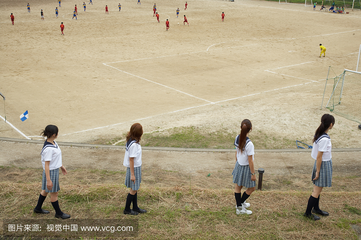 四名十几岁的女孩(15-18岁)在校服看足球比赛