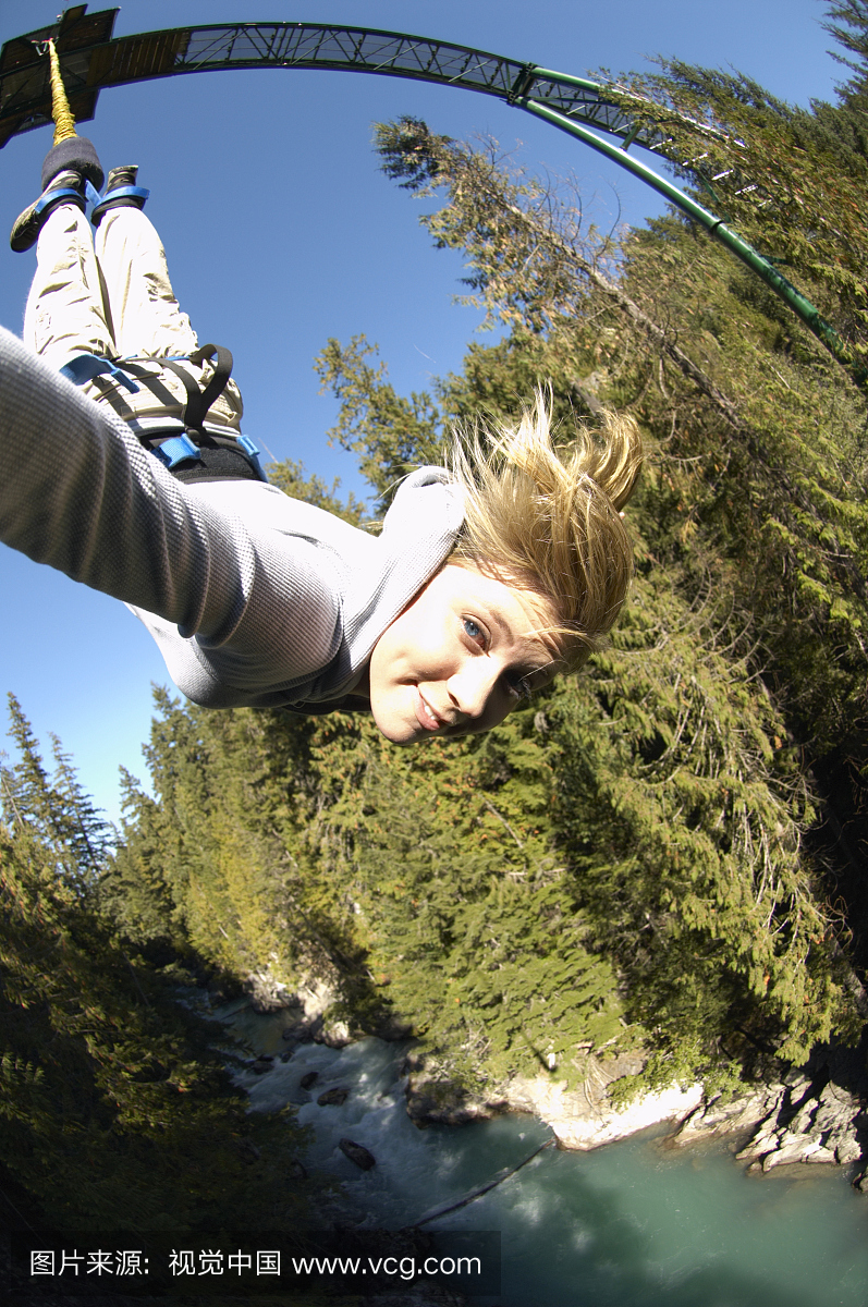 从蹦极跳绳,肖像倒挂的年轻女子