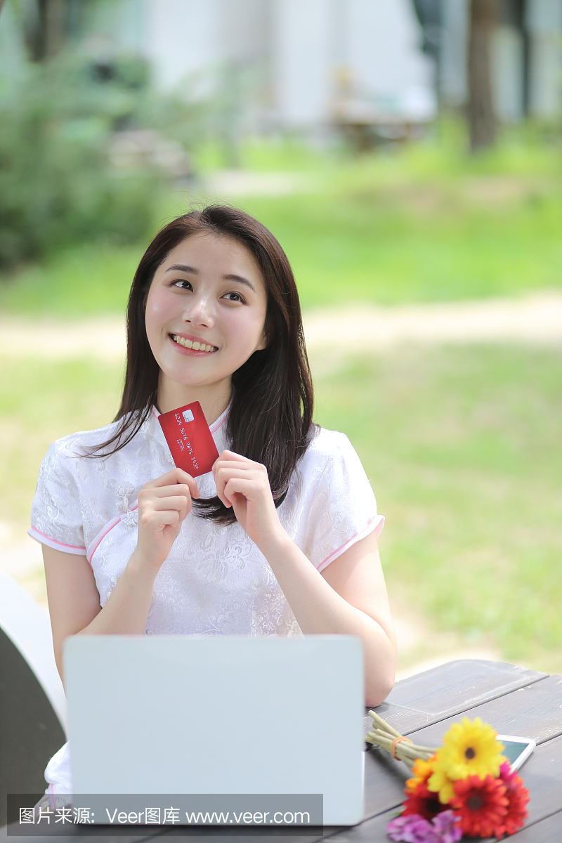 年轻女子在中国服饰网上购物与信用卡在咖啡厅