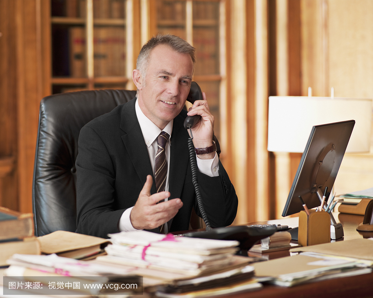 律师在电话中说话,并在办公室打手势
