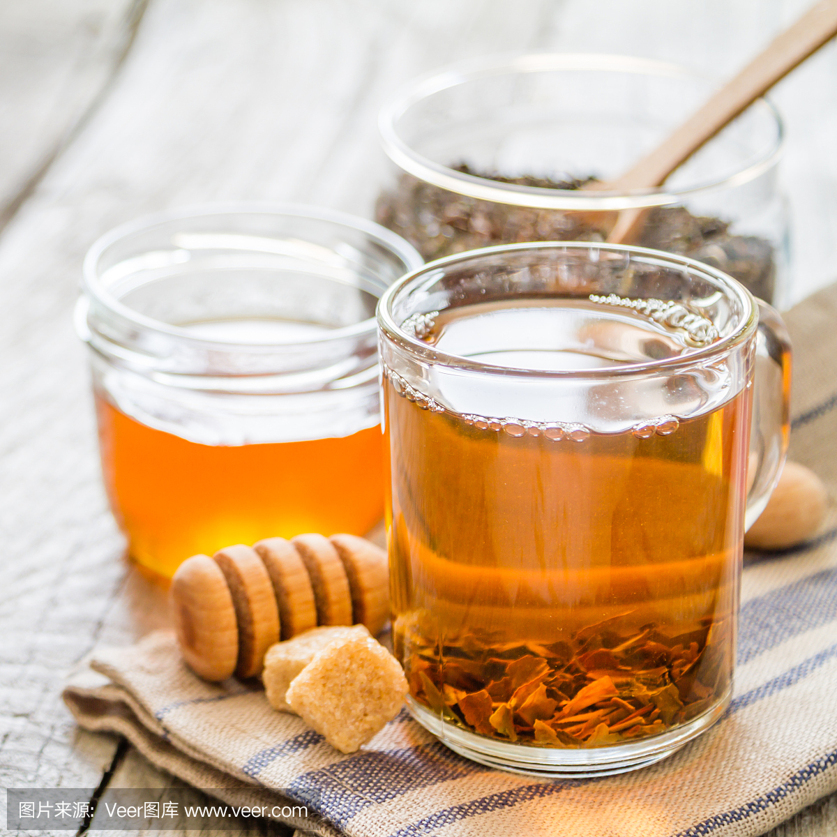 红茶在玻璃杯,糖,蜂蜜,乡村木背景