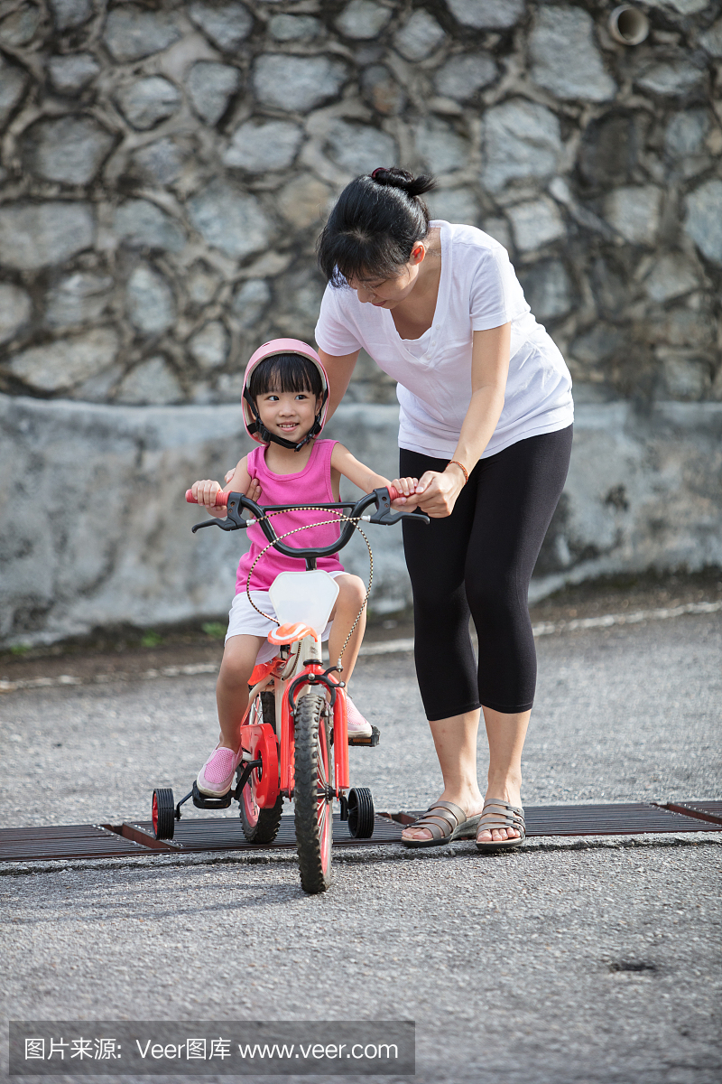 亚洲中国小女孩骑马与妈妈指导
