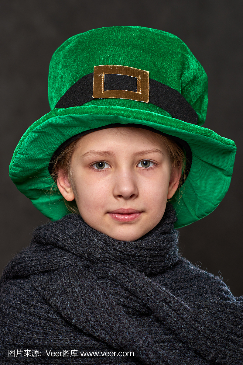 年轻女孩在绿色妖精的帽子和灰色针织围巾