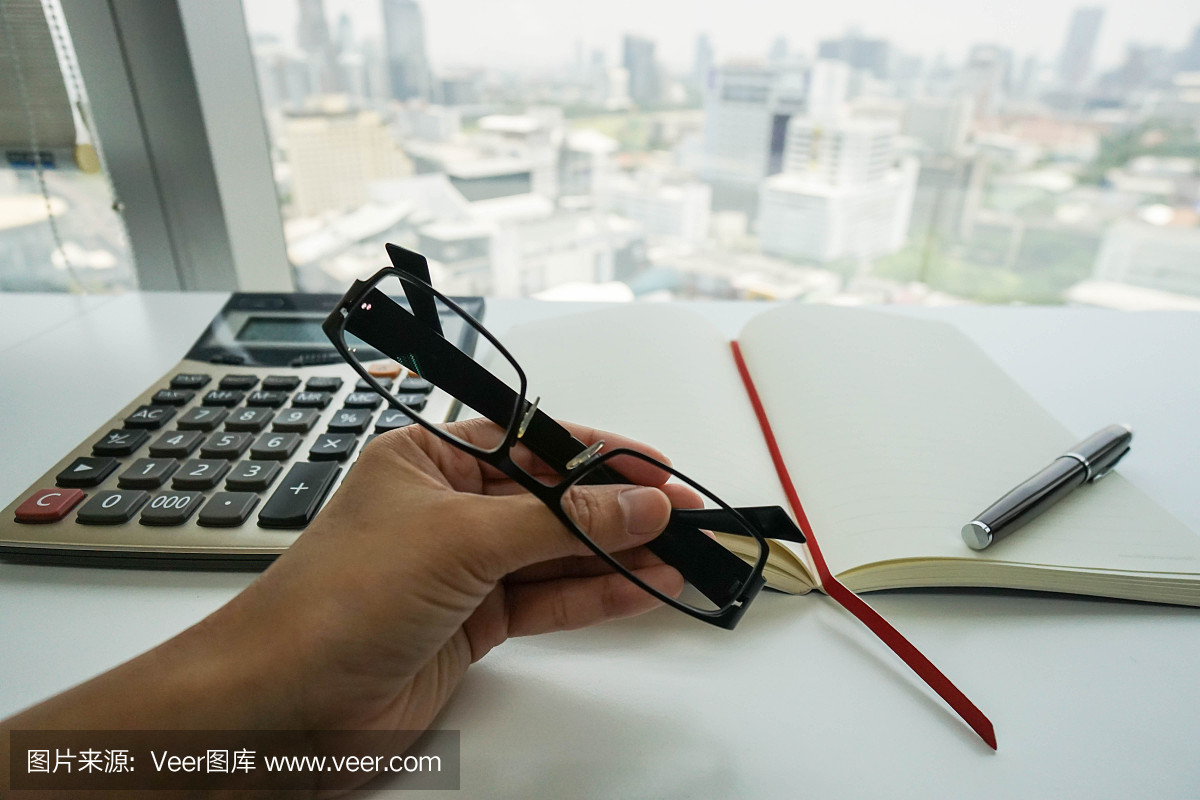 女企业家用眼镜工作的预算和税务与计算器在办