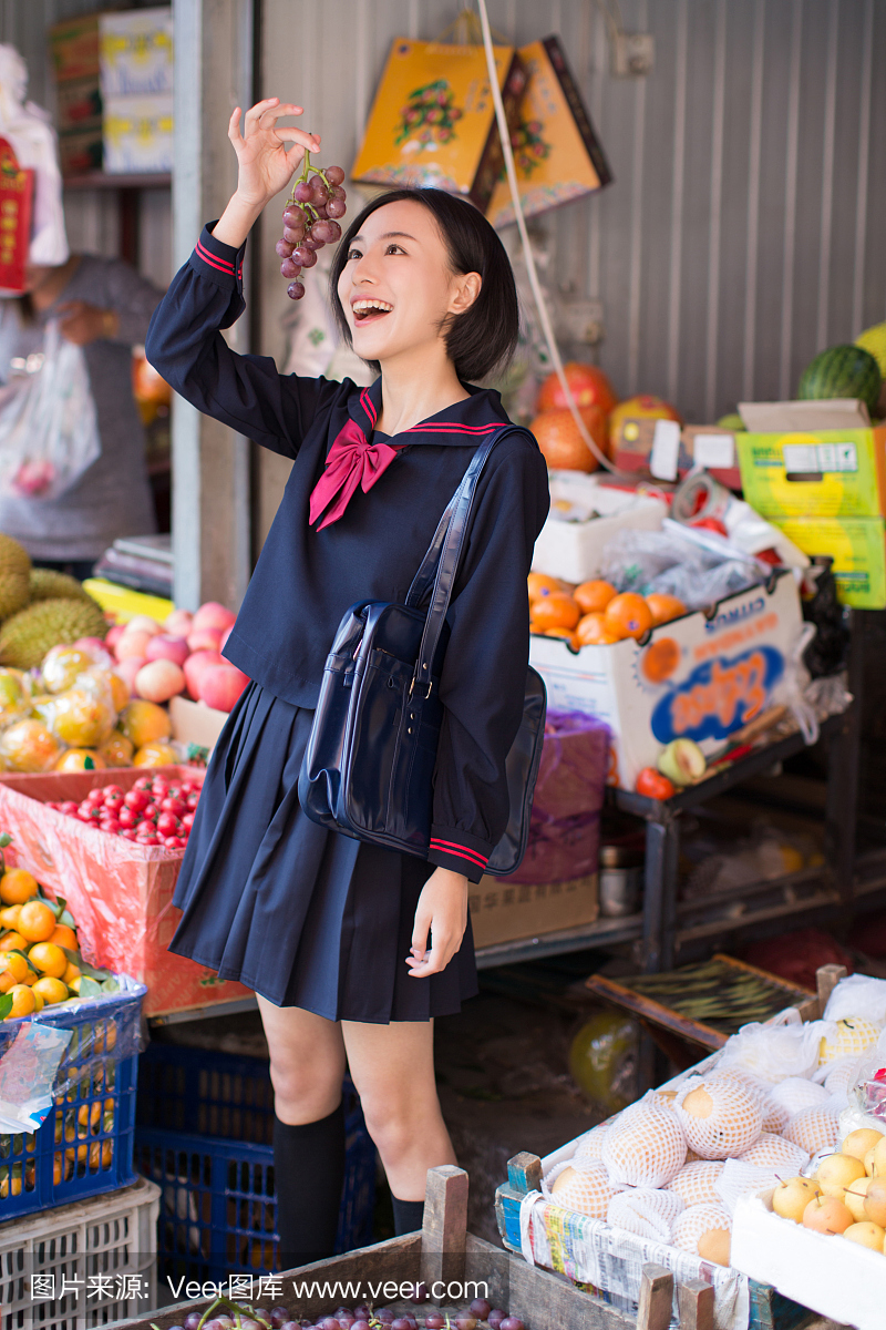 美丽的中国女学生在市场上买水果和蔬菜