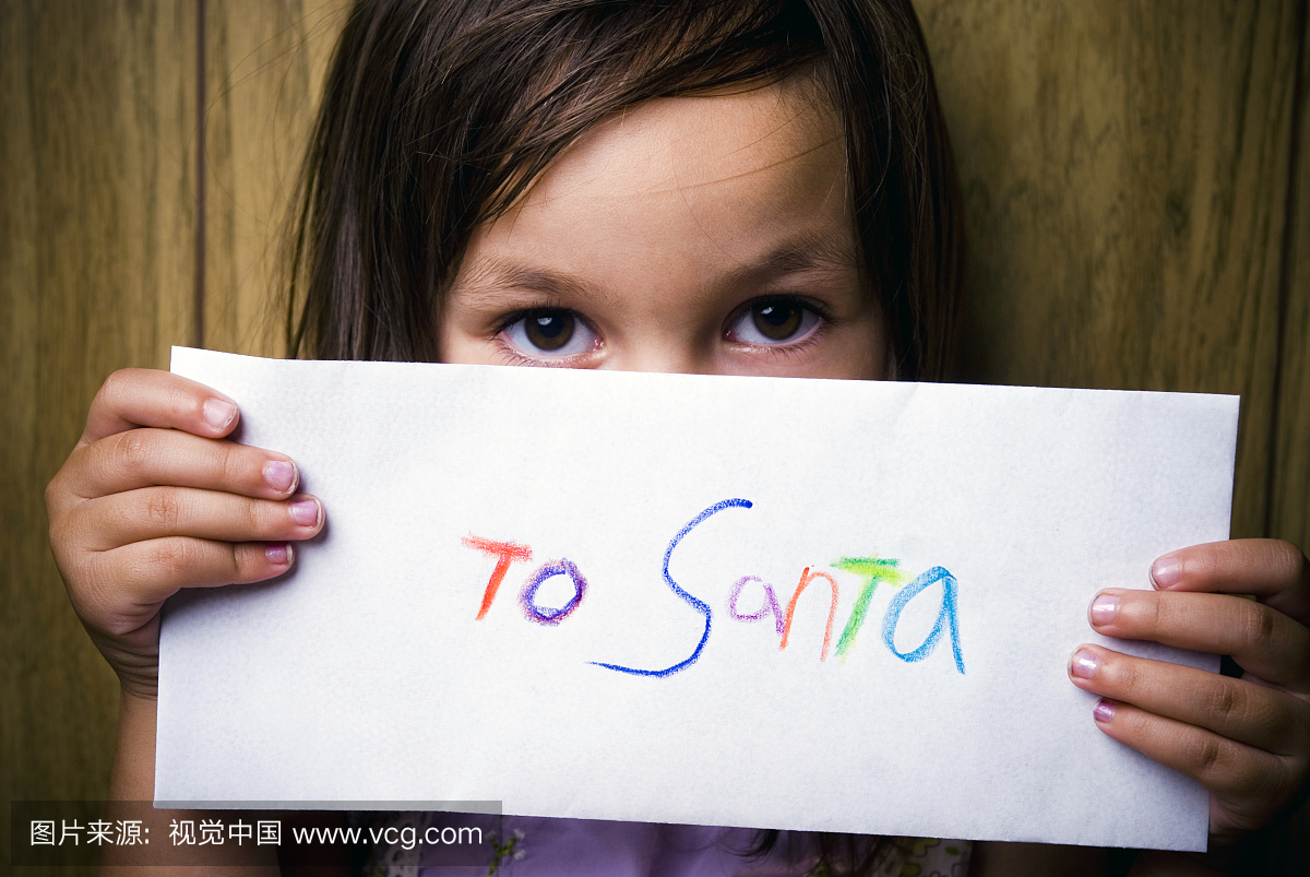 害羞的小女孩抱着一封信给圣诞老人