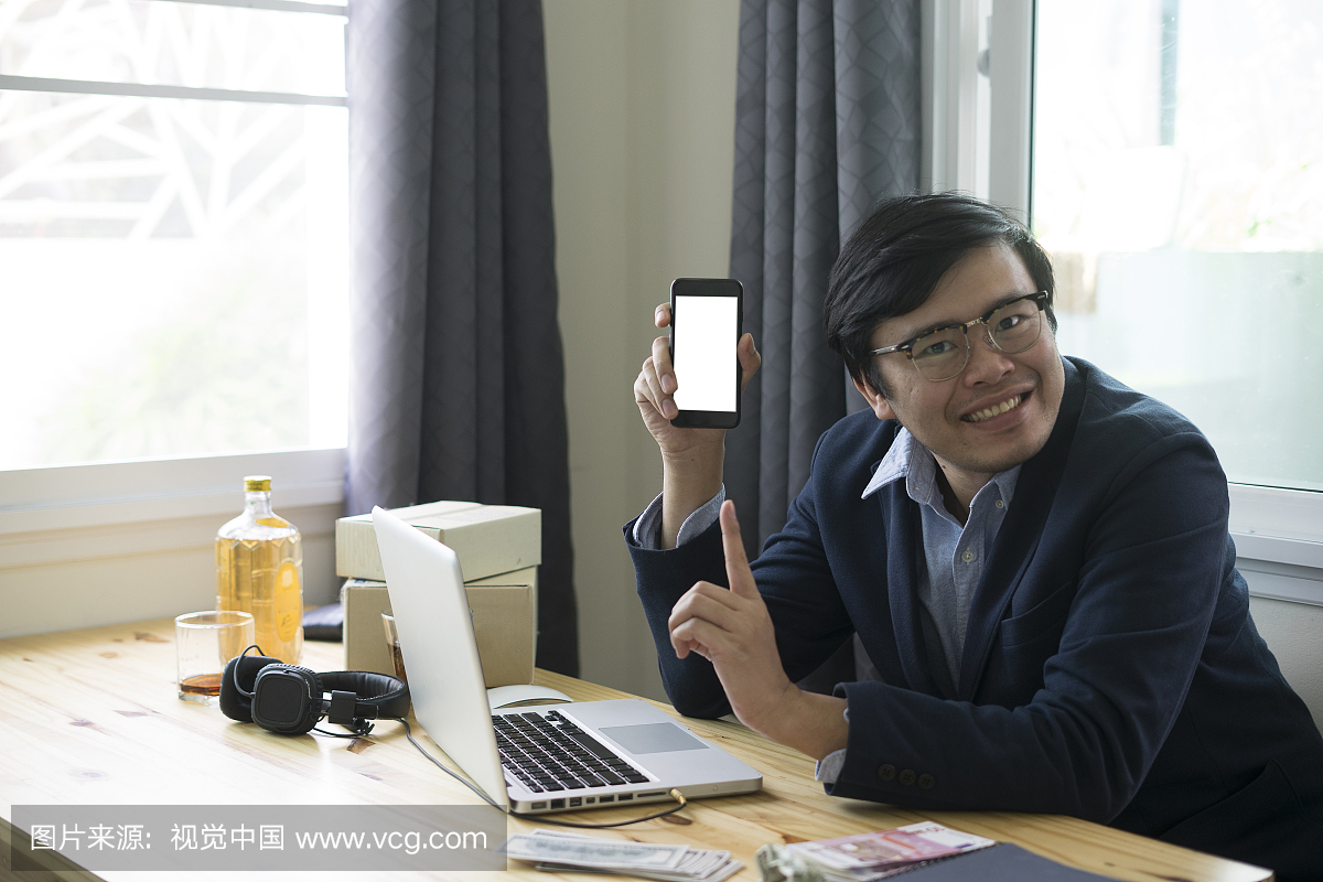 亚洲业务男子手持智能手机和平板电脑与在线购
